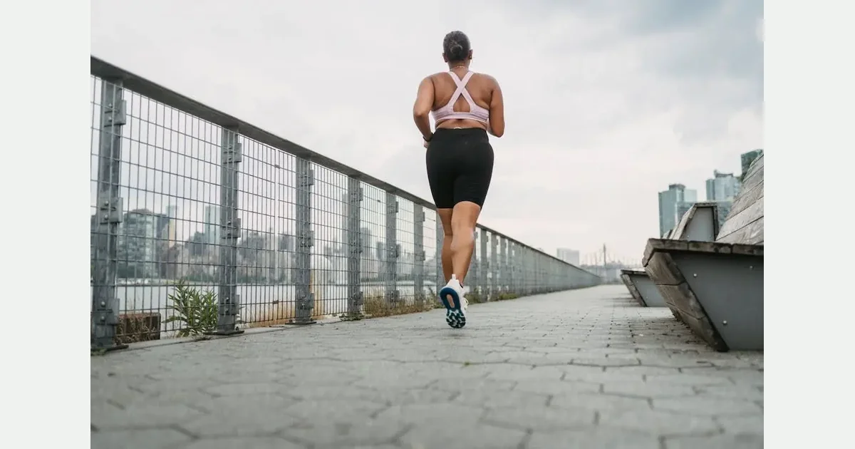 Person jogging outdoors beside an urban waterfront