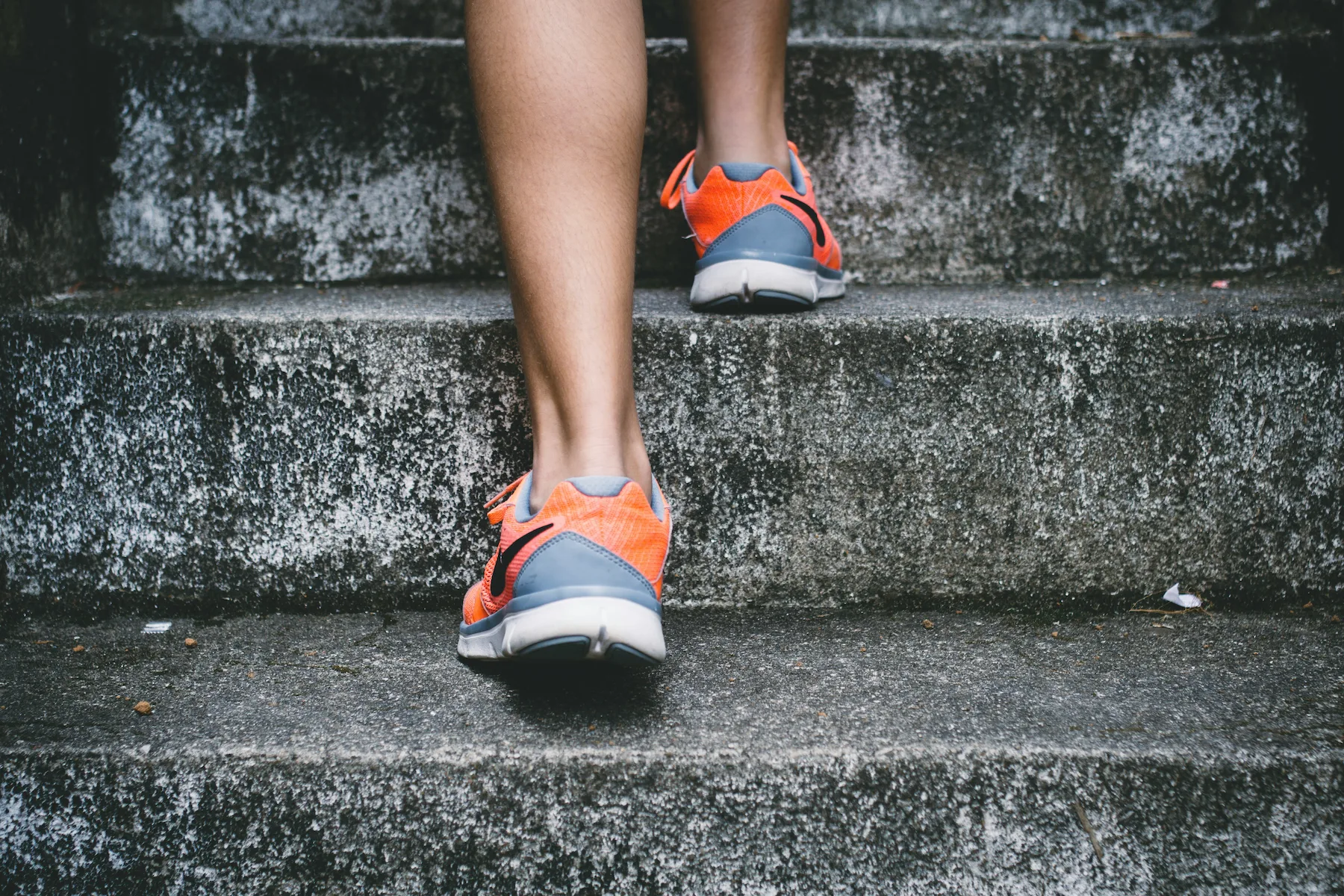 Close-up of a person wearing athletic shoes climbing outdoor steps