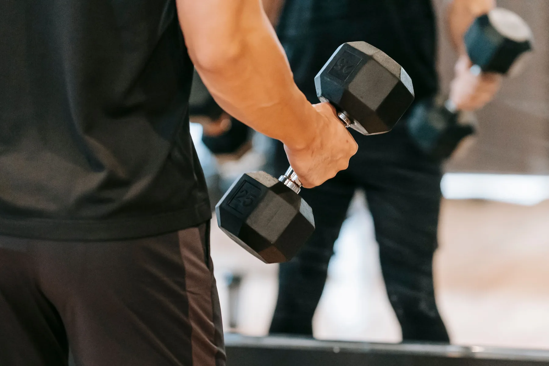 Male hand picking up exercise weights